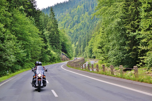 Two people riding a motorcycle on a rural road