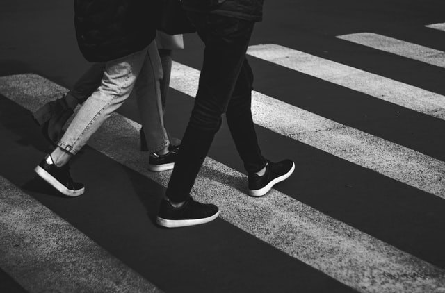 Two pedestrians use a crosswalk.